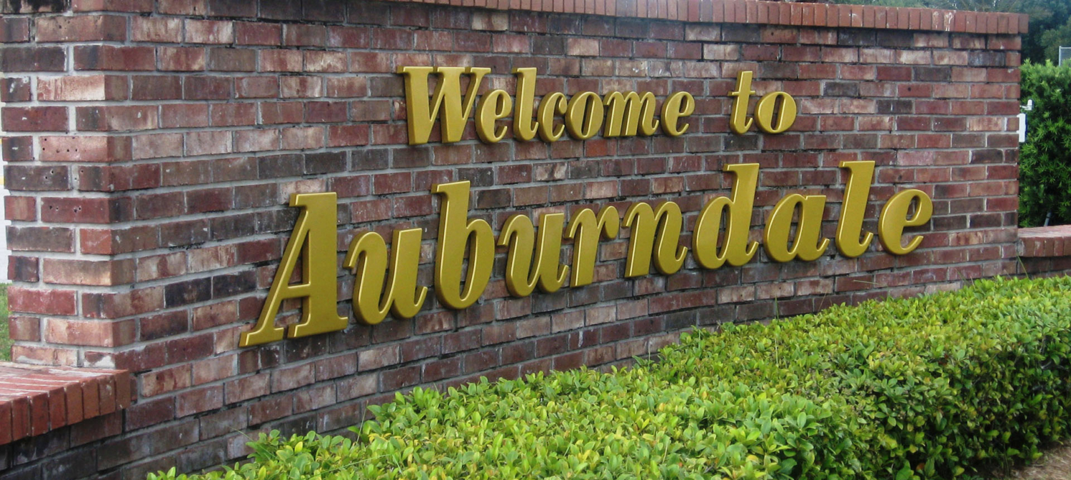 A masonry sign that reads "Welcome to Auburndale"