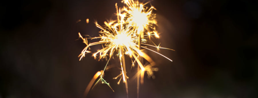 A hand holding two sparklers