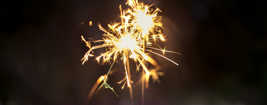A hand holding two sparklers