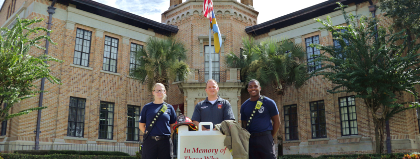 Two firefighters and Fire Chief in front of City Hall